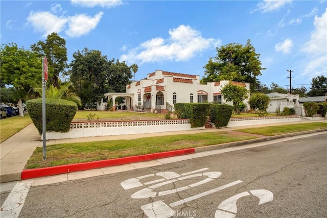 mediterranean / spanish-style home featuring a front lawn and stucco siding