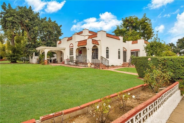 view of front of property with a tiled roof, stucco siding, a front yard, and a pergola