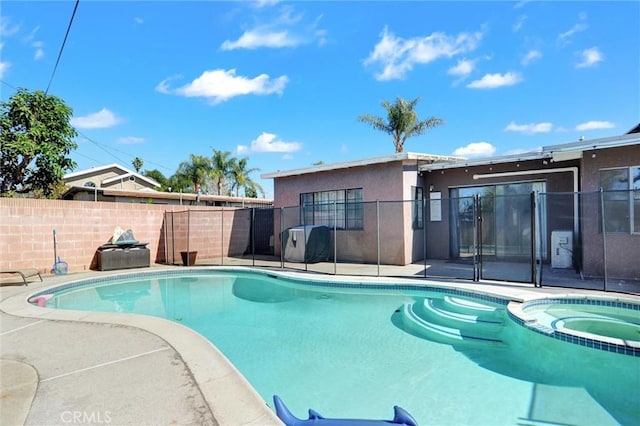 view of swimming pool with a pool with connected hot tub, fence, and a patio