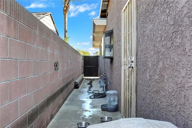 view of side of property with fence and stucco siding