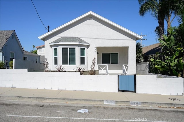 bungalow-style house featuring fence and stucco siding