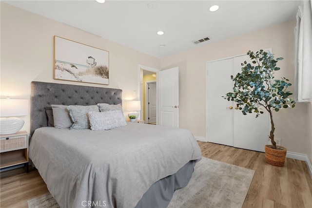 bedroom with baseboards, wood finished floors, visible vents, and recessed lighting