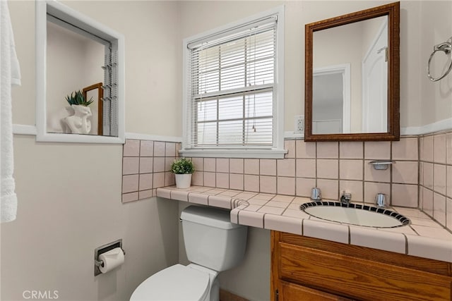 bathroom featuring decorative backsplash, vanity, and toilet