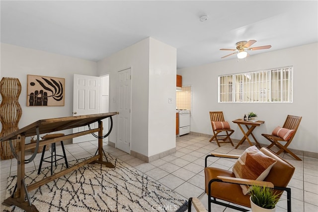 office space featuring ceiling fan, baseboards, and light tile patterned flooring