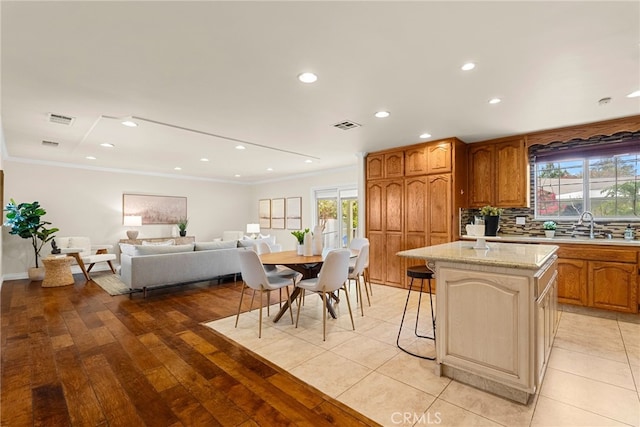 kitchen featuring backsplash, visible vents, and crown molding