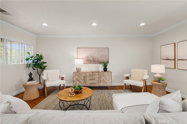 living area featuring visible vents, crown molding, baseboards, and wood finished floors