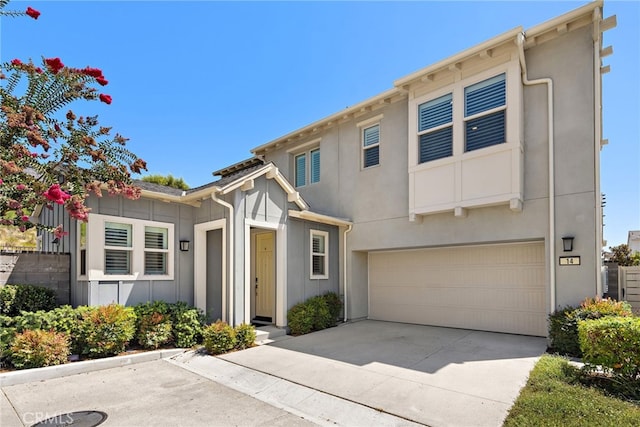 view of front of property with a garage, concrete driveway, and stucco siding