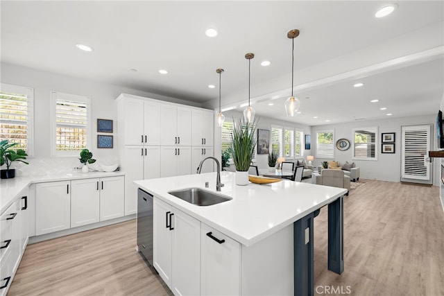 kitchen with dishwasher, light wood-style floors, a sink, and recessed lighting