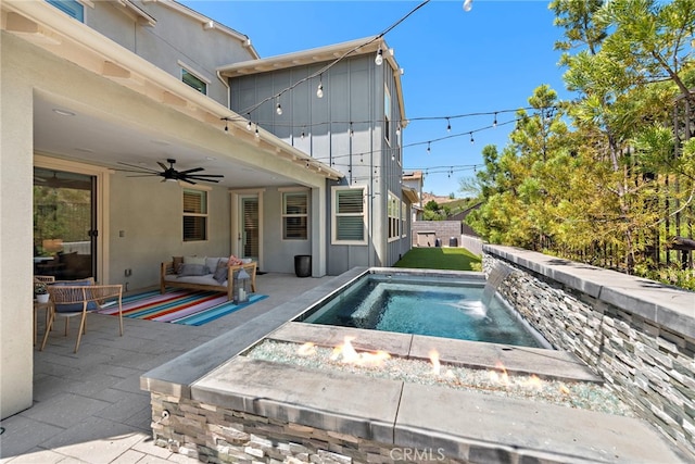 view of swimming pool with an outdoor living space with a fire pit, ceiling fan, and a patio