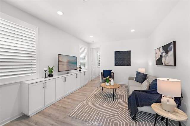 living room with light wood-style floors, recessed lighting, and baseboards