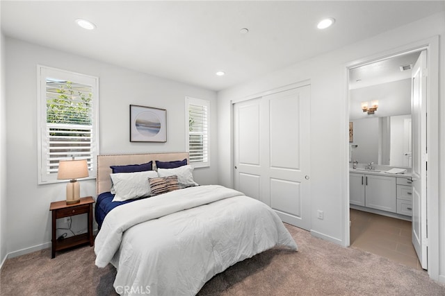 bedroom featuring light carpet, visible vents, a sink, a closet, and recessed lighting