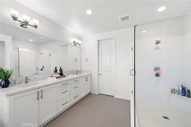 full bath with a stall shower, visible vents, a sink, and double vanity