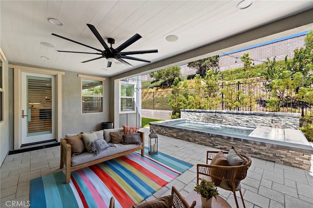 view of patio / terrace featuring ceiling fan, an outdoor hot tub, fence, and outdoor lounge area