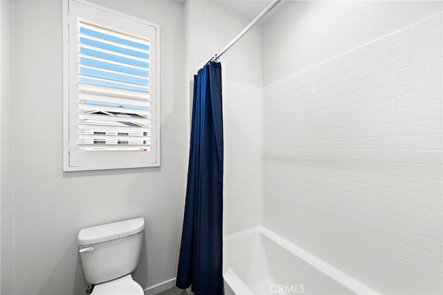 bathroom with shower / tub combo with curtain and toilet