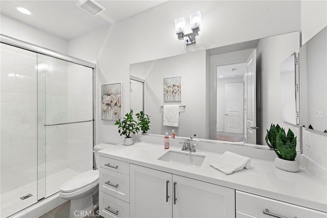 bathroom with toilet, recessed lighting, vanity, visible vents, and a stall shower