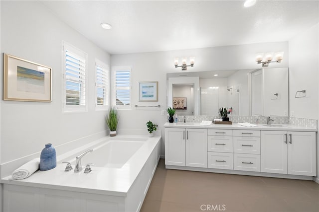 bathroom with a garden tub, double vanity, a sink, and a shower stall