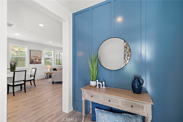 interior space with recessed lighting, visible vents, a decorative wall, and wood finished floors