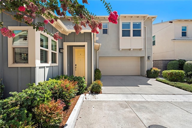 view of front facade featuring driveway, a garage, and stucco siding