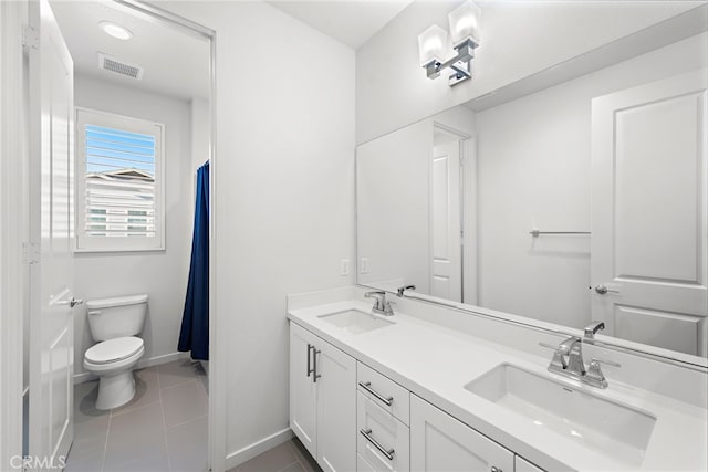 bathroom with toilet, a sink, visible vents, and tile patterned floors