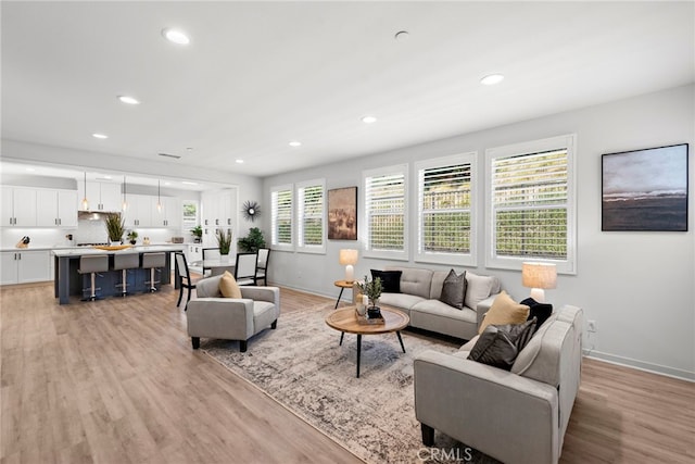 living area featuring light wood finished floors and recessed lighting