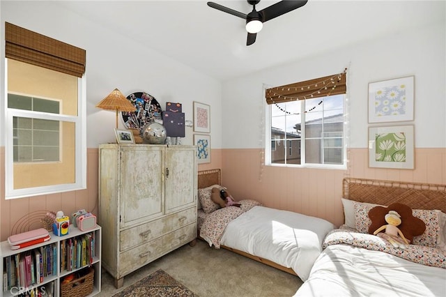 bedroom with carpet, wainscoting, and a ceiling fan