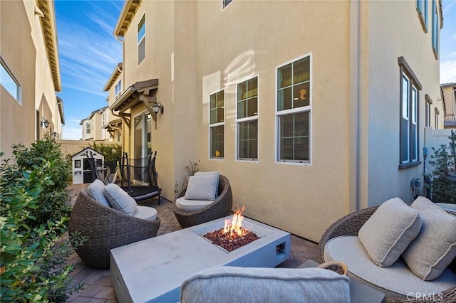 view of patio with an outdoor living space with a fire pit