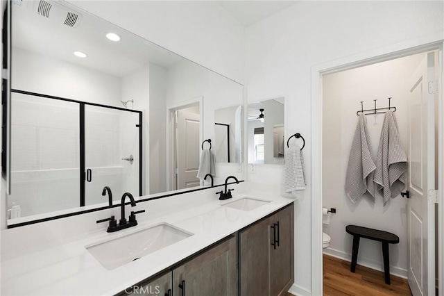 full bathroom with a stall shower, visible vents, a sink, and double vanity