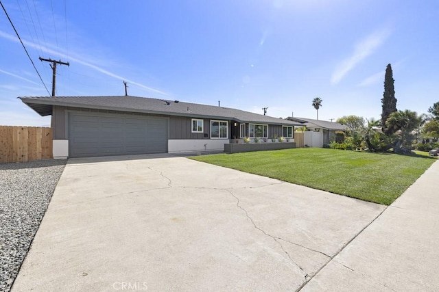 ranch-style house with a garage, fence, concrete driveway, and a front yard