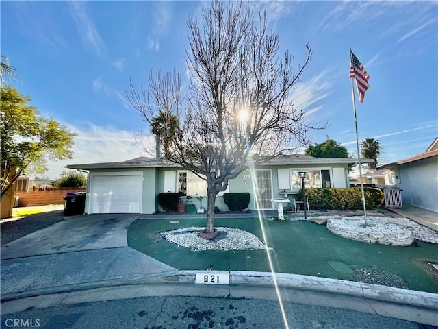 ranch-style home with a garage, fence, concrete driveway, and stucco siding