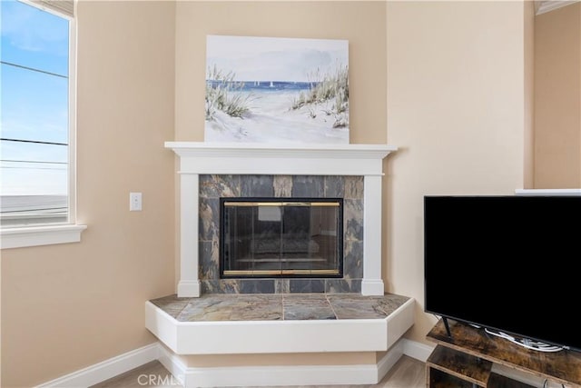 details featuring baseboards and a tile fireplace