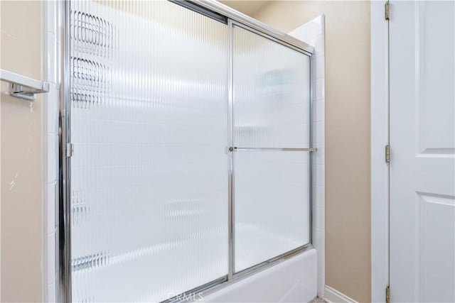 full bath featuring bath / shower combo with glass door