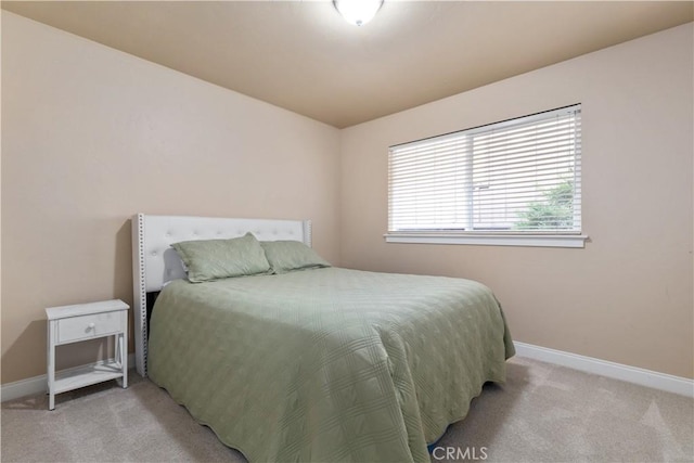 bedroom with light carpet and baseboards