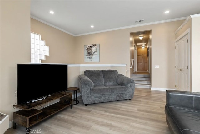 living room with baseboards, visible vents, light wood finished floors, and ornamental molding