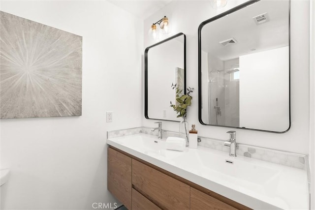 full bathroom with a shower, visible vents, a sink, and double vanity