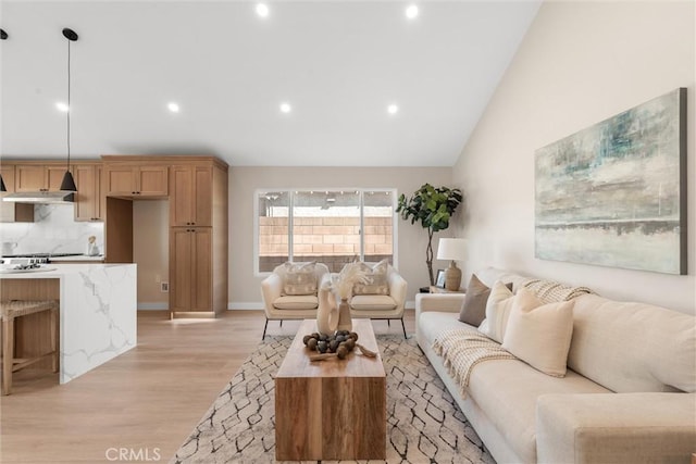 living area featuring baseboards, high vaulted ceiling, recessed lighting, and light wood-style floors