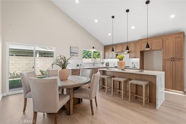 dining space with light wood-style floors, recessed lighting, and high vaulted ceiling