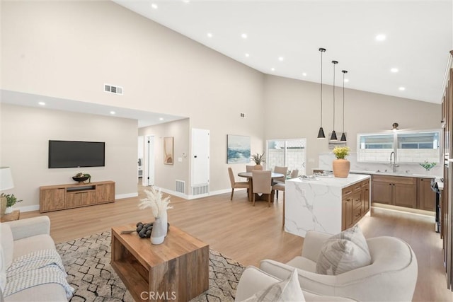 living area featuring light wood-type flooring, visible vents, and recessed lighting