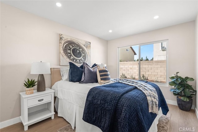 bedroom featuring baseboards, wood finished floors, and recessed lighting