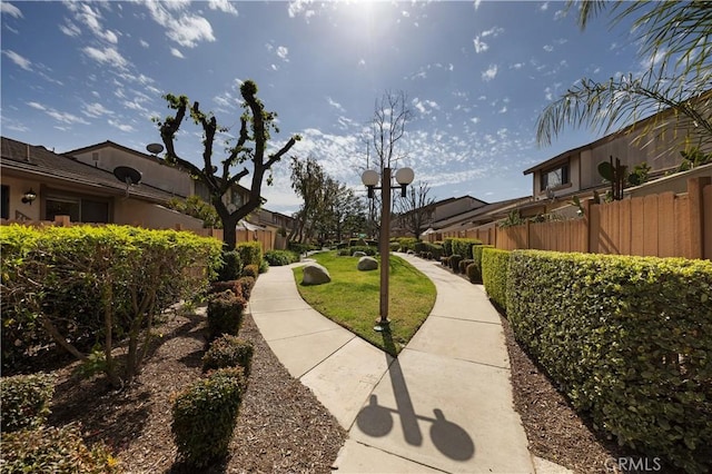 view of home's community featuring a yard, a residential view, and fence