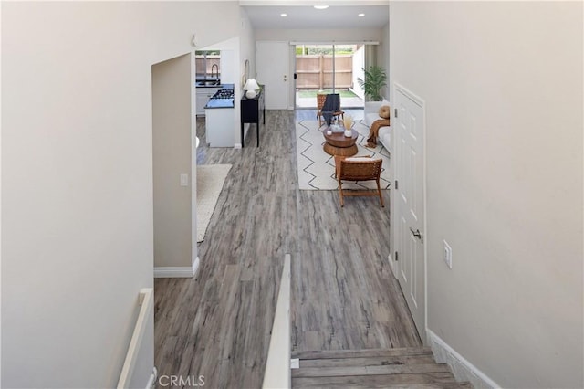 corridor with recessed lighting, baseboards, and wood finished floors