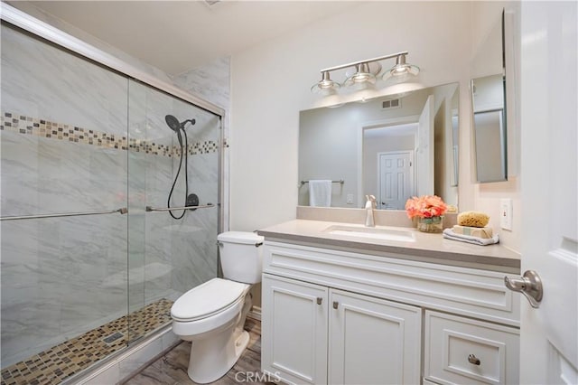 full bath featuring visible vents, a shower stall, toilet, and vanity