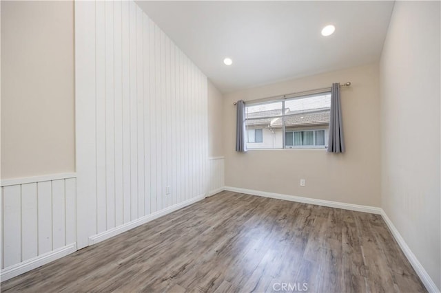 unfurnished room with baseboards, wood finished floors, and recessed lighting