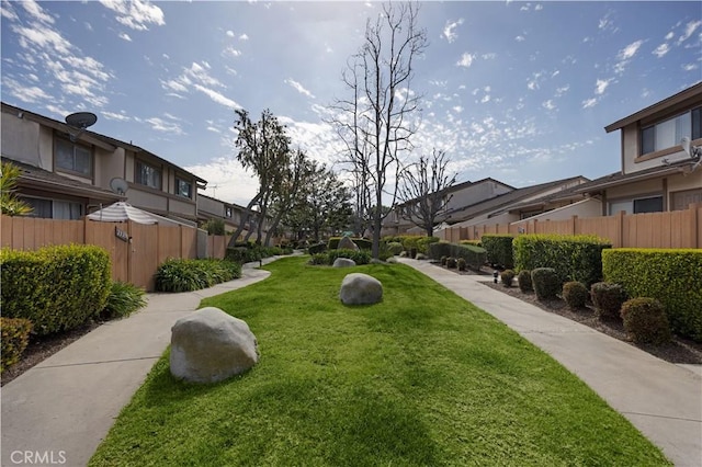 surrounding community with a yard, fence, and a residential view