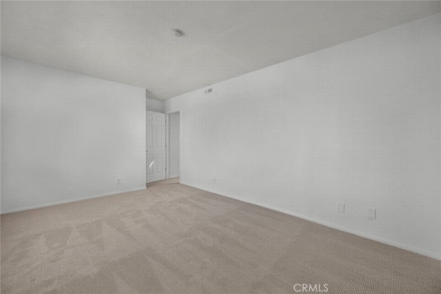 unfurnished room featuring light carpet