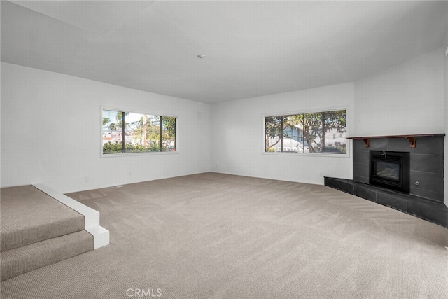 unfurnished living room featuring carpet and a fireplace