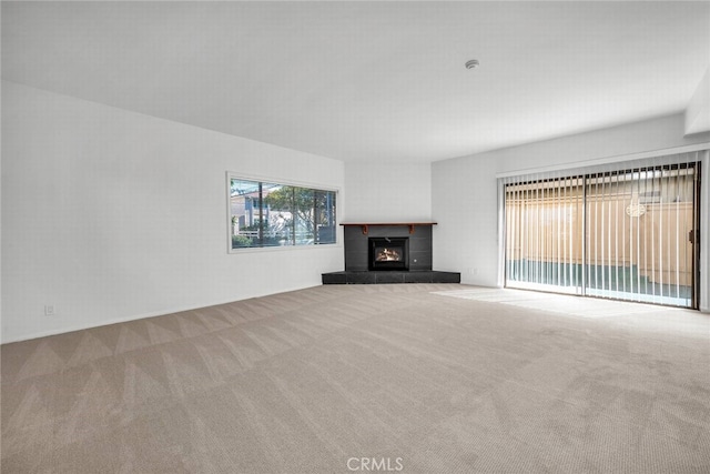 unfurnished living room featuring carpet floors and a tiled fireplace