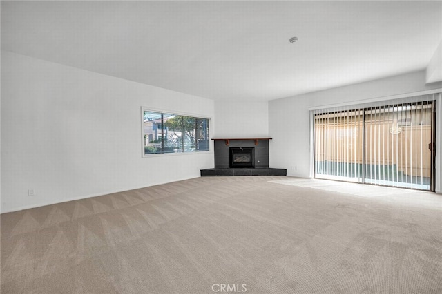 unfurnished living room featuring carpet floors and a tiled fireplace