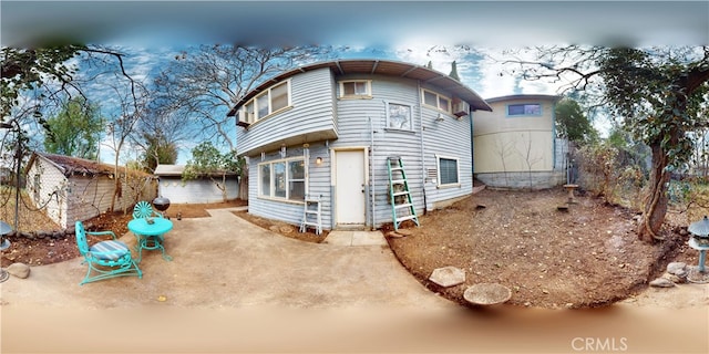 rear view of house featuring an outbuilding and a patio