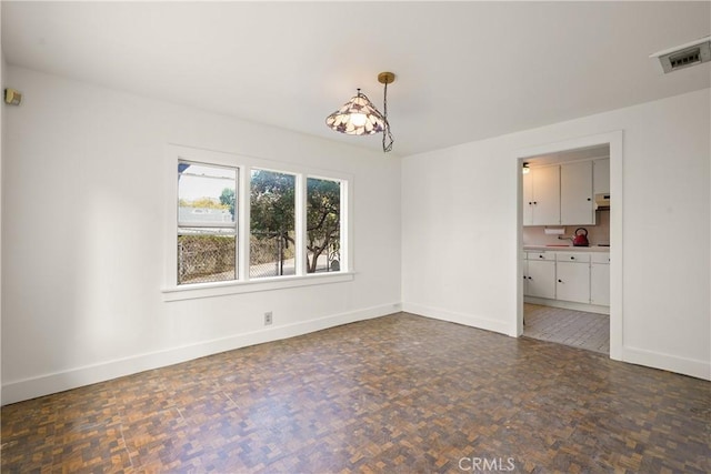 spare room with visible vents and baseboards