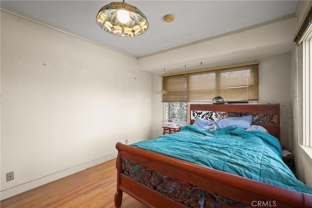 bedroom featuring crown molding, baseboards, and wood finished floors